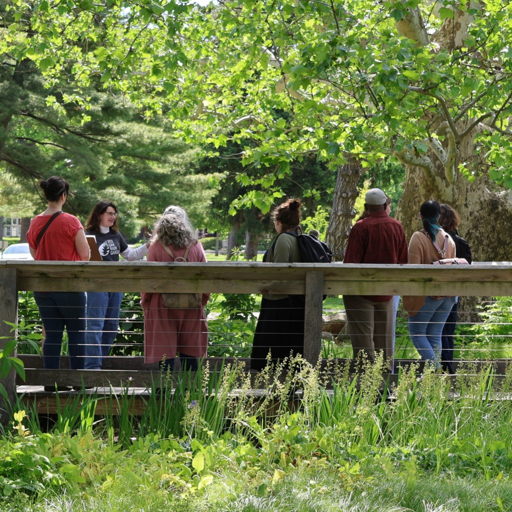 Erin Schimenti stands on RORG's boardwalk bridge with several tourists.